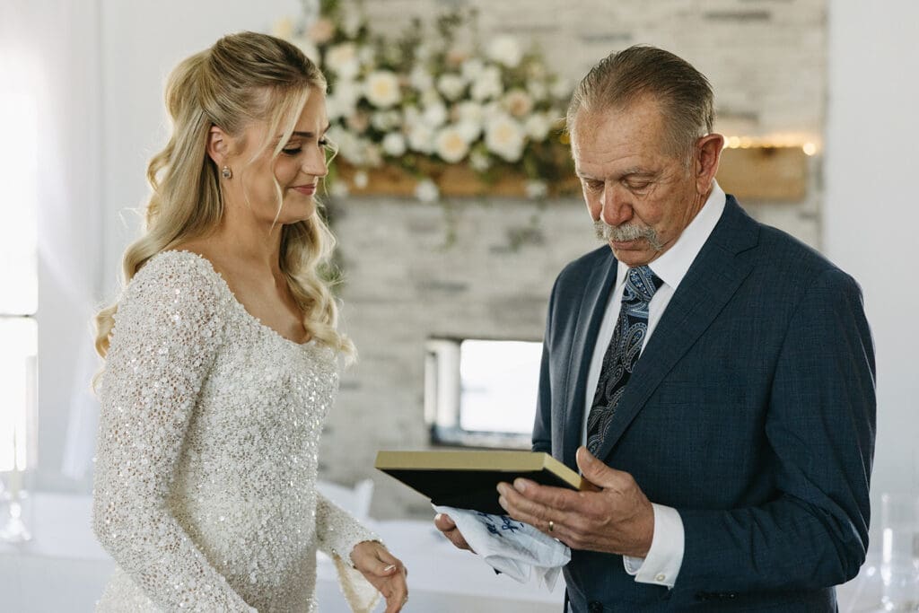 Bride gives father a gift before her wedding.