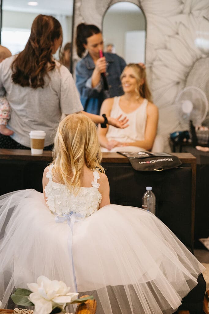 Flower girl watching bride get ready for wedding day.