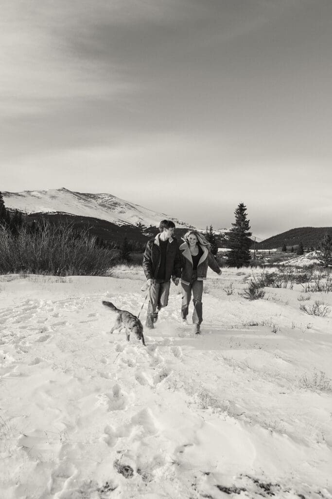 engagement photos taken in breckinridge colorado with a dog and a snowy mountain background
