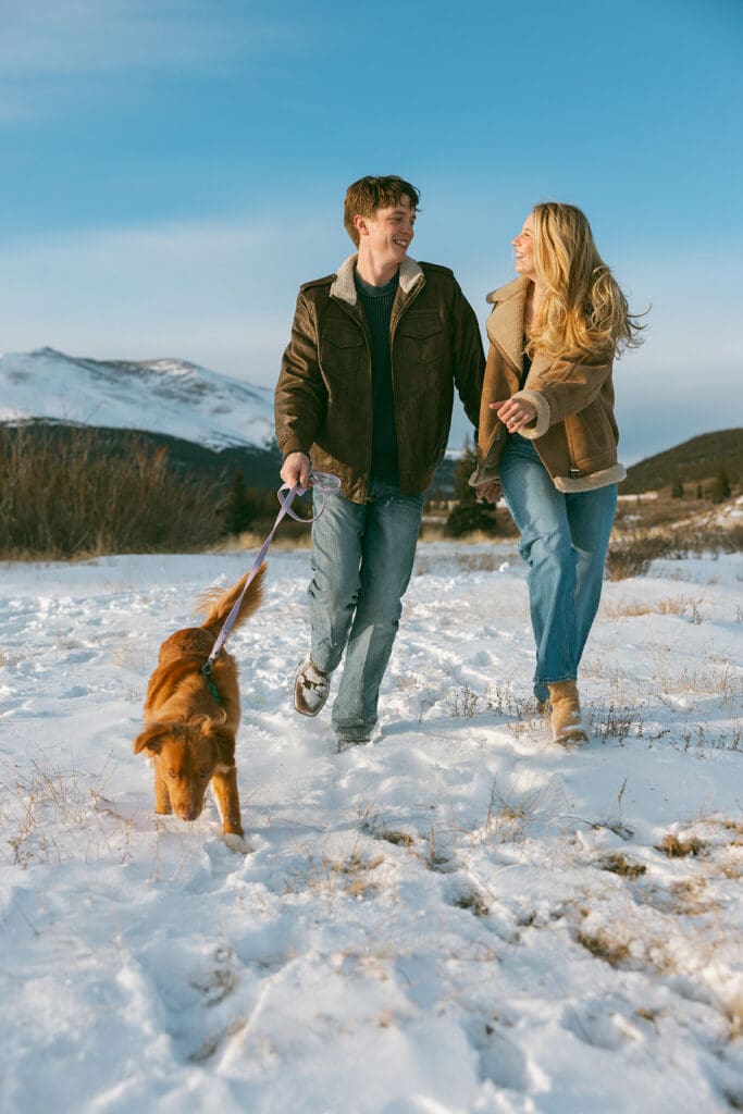 engagement photos taken in breckinridge colorado with a dog and a snowy mountain background