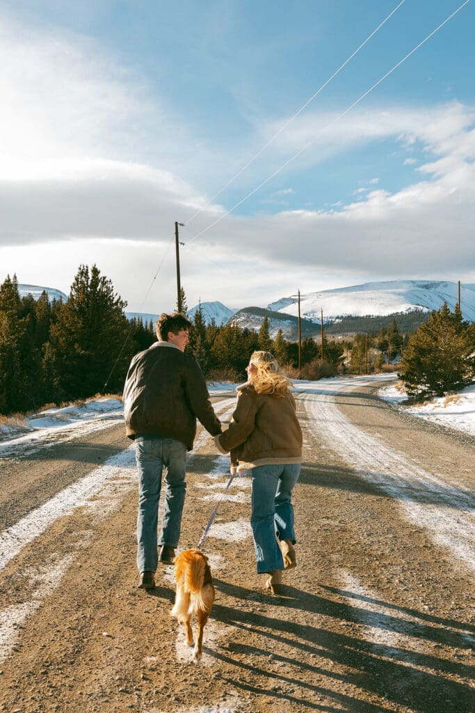 engagement photos taken in breckinridge colorado with a dog and a snowy mountain background