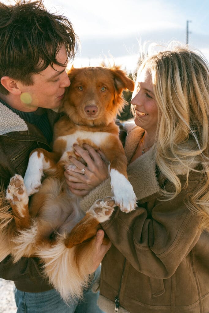 engagement photos taken in breckinridge colorado with a dog and a snowy mountain background