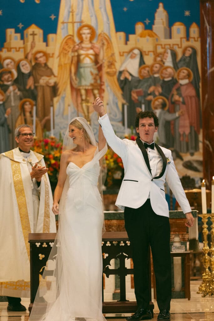 bride and groom celebrating at altar in elegant catholic ceremony in kansas city