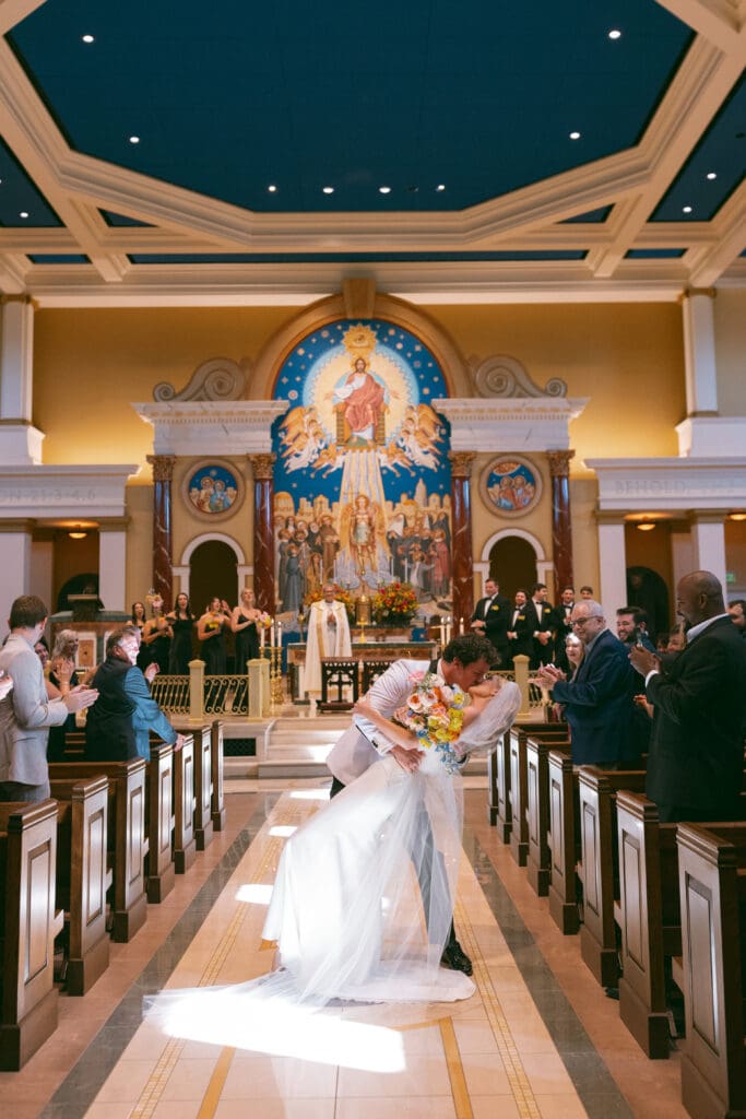 bride and groom dip kiss in elegant catholic ceremony in kansas city