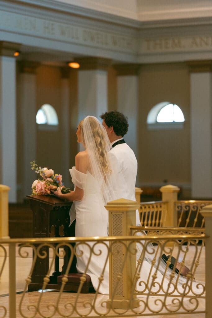 bride and groom at altar in elegant catholic ceremony in kansas city