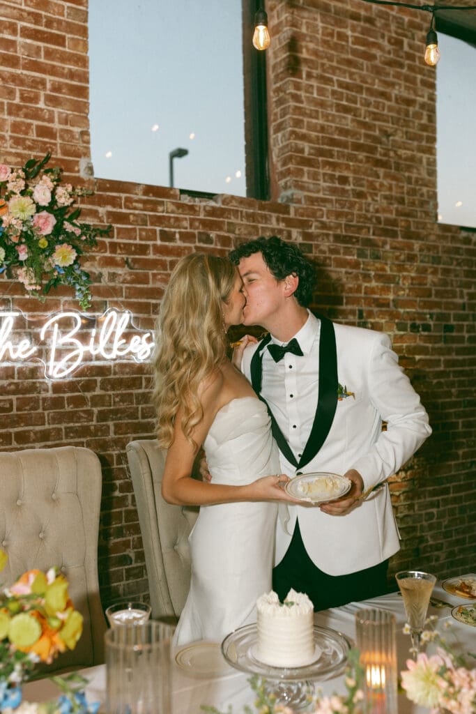 bride and groom kissing in colorful, luxurious wedding reception in kansas city