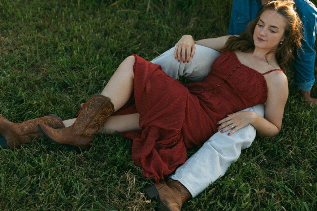 woman laying on man during engagement session in kansas city