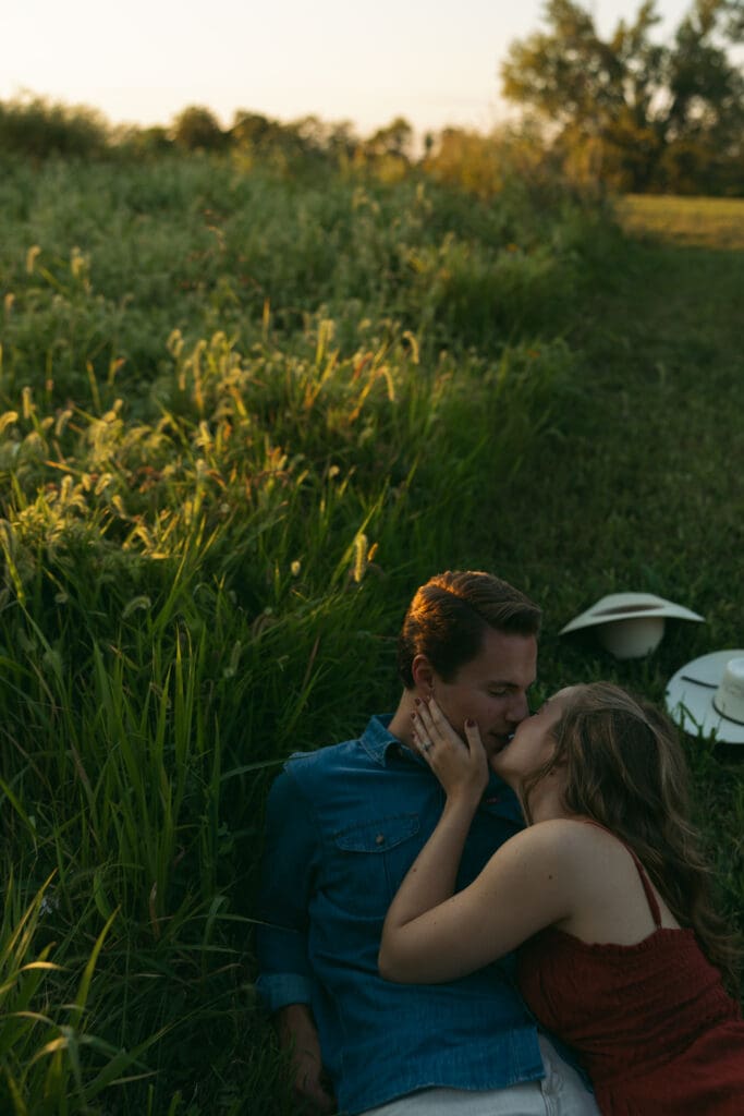woman and man kissing during engagement session in kansas city