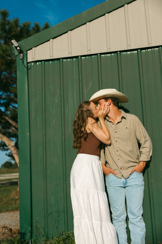 woman and man kissing during engagement session in kansas city